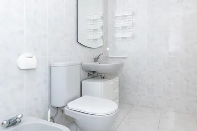 a white bathroom with a toilet and a sink at Villas Cap Blanc Ii, Pta 11 in Cullera