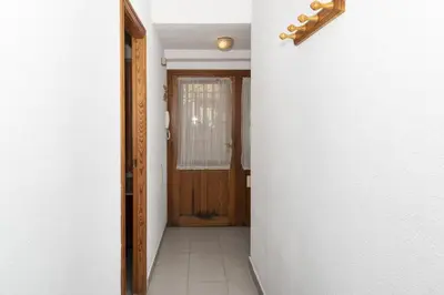 a hallway with a wooden door and a tile floor at Villas Cap Blanc, 1-31 Cab I-36 in Cullera