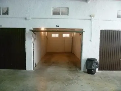 an empty garage with two doors and a trash can at Villas Cap Blanc, 1-31 Cab I-36 in Cullera