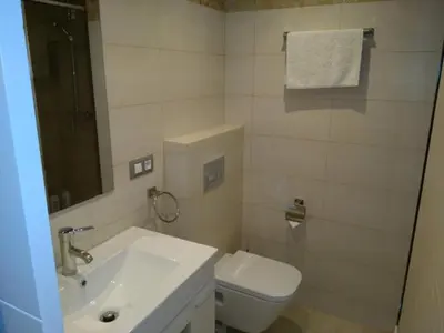 a white bathroom with a sink and a toilet at Apartamentos BARRACA in Valencia
