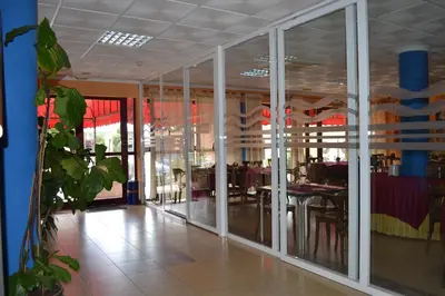 a restaurant with glass doors and a dining area at Portocanet Complejo Turístico in Canet de Berenguer
