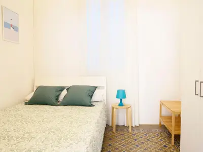 a bedroom with a bed and a table with a blue lamp at City Hall Correos in Valencia