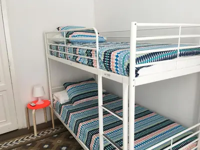 two bunk beds in a small room with a red stool at City Hall Correos in Valencia