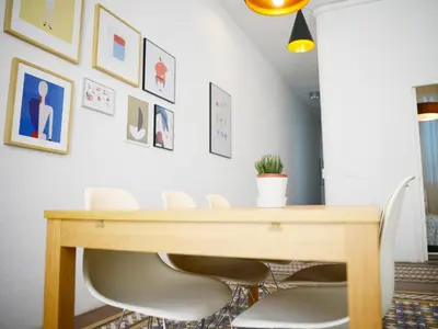 a dining room with a wooden table and white chairs at City Hall Correos in Valencia