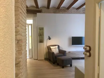 a living room with a chair and a tv at Teixidors de Palomar - PalomarGroup in Valencia