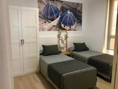 a bedroom with two beds and an umbrella painting on the wall at Teixidors de Palomar - PalomarGroup in Valencia
