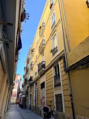 an alley with a yellow building and a bike parked next to it at Teixidors de Palomar - PalomarGroup in Valencia
