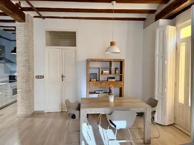 a kitchen and dining room with a wooden table and chairs at Teixidors de Palomar - PalomarGroup in Valencia
