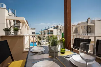 a table with glasses and a bottle of wine on a balcony at SingularStays Puzol Beach VI in Puzol
