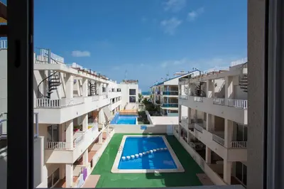 a view from a window of an apartment building with a swimming pool at SingularStays Puzol Beach VI in Puzol