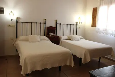 two beds in a room with white sheets at Hotel La Villa in Requena