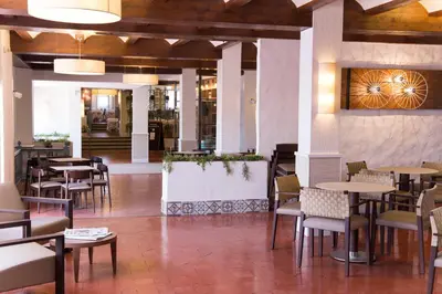 a restaurant with tables and chairs and a lobby at Hotel La Carreta in Chiva