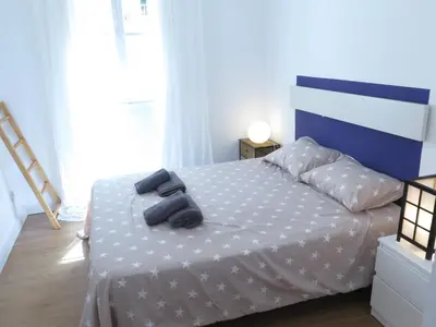 a bedroom with a white bed with two black towels on it at La Roqueta completo en pleno centro in Valencia
