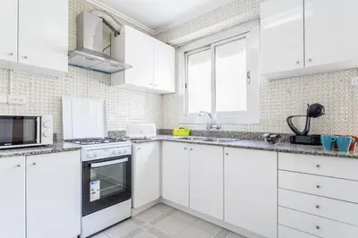 a white kitchen with white cabinets and appliances at Casa Victoria in Valencia