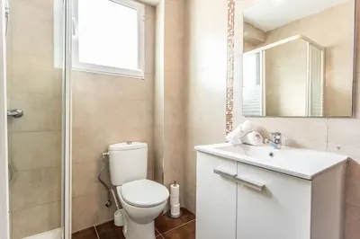 a bathroom with a toilet and a sink and a mirror at Casa Victoria in Valencia