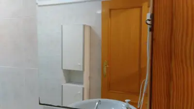 a bathroom with a sink and a wooden door at Apartamento Ciudad de las Ciencias 2 in Valencia