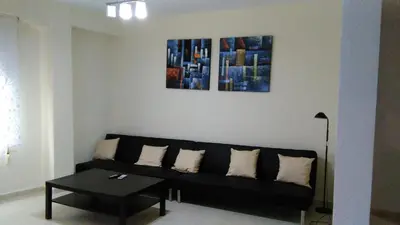 a living room with a black couch and two paintings at Apartamento Ciudad de las Ciencias 2 in Valencia