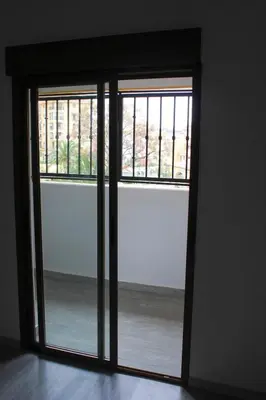an open glass door with a view of the ocean at Apartment in Little Venice in Port Saplaya