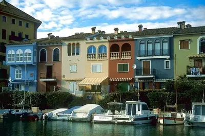 a group of boats docked in the water near buildings at Apartment in Little Venice in Port Saplaya