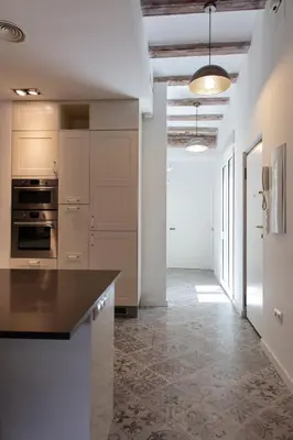 a kitchen with white cabinets and a black counter top at FLORIT FLATS - Serranos Apartment in Valencia