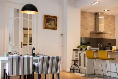 a kitchen with a dining table and yellow chairs at FLORIT FLATS - Serranos Apartment in Valencia