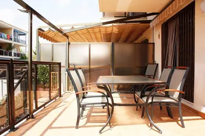 a patio with a table and chairs on a balcony at Apartamento junto al mar Los Marineros con acceso independiente por terraza in Puzol