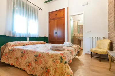 a bedroom with a bed and a chair and a window at Villamilagro in Sueca