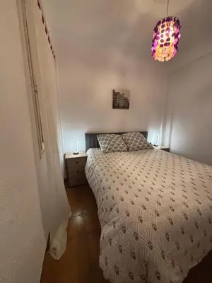 a bedroom with a bed and a chandelier at Apartamento La Marina Real in Valencia