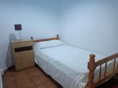 a small bedroom with a bed and a night stand at Apartamento La Marina Real in Valencia