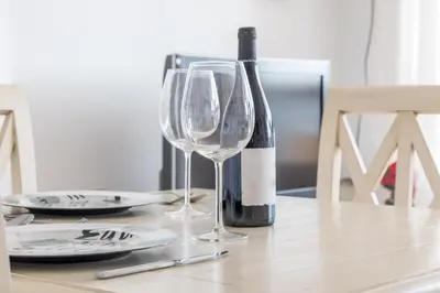 a bottle of wine and two wine glasses on a table at Apartamento Calipso in El Palmar