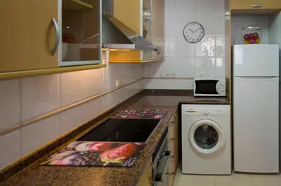 a kitchen with a sink and a washing machine at ApartUP Francia Views in Valencia