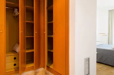 a closet with wooden cabinets in a bedroom at ApartUP Francia Views in Valencia