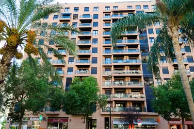 an apartment building with palm trees in front of it at ApartUP Francia Views in Valencia