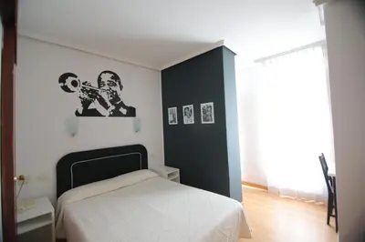 a bedroom with a white bed and a black wall at Hotel Valencia de la Música in Valencia