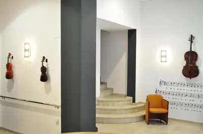 a room with two violins on the wall and a chair at Hotel Valencia de la Música in Valencia