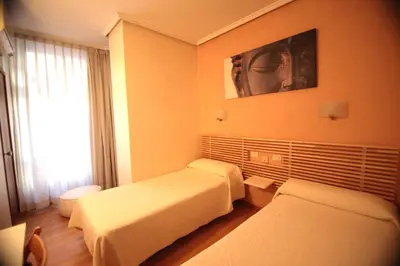 a hotel room with two beds and a window at Hotel Valencia de la Música in Valencia