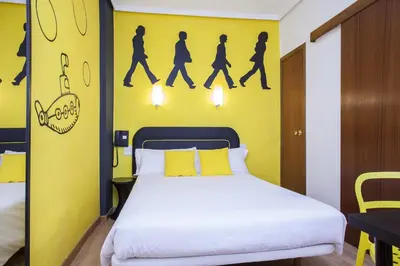 a bedroom with a bed and a yellow wall at Hotel Valencia de la Música in Valencia