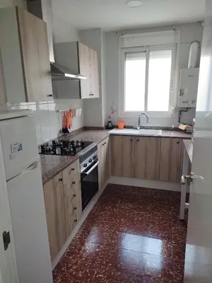 a kitchen with wooden cabinets and a stove and a window at Apartamento Cuatro Carreres in Valencia