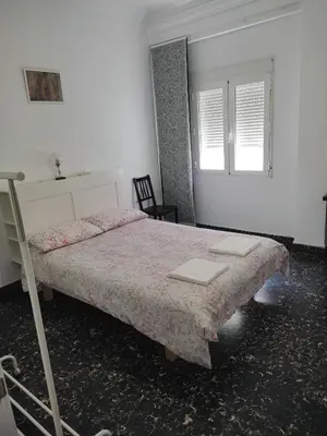a bedroom with a large bed and a window at Apartamento Cuatro Carreres in Valencia