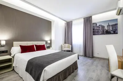 a hotel room with a large bed with red pillows at Sweet Hotel Renasa in Valencia
