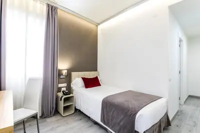 a hotel room with a bed and a chair at Sweet Hotel Renasa in Valencia