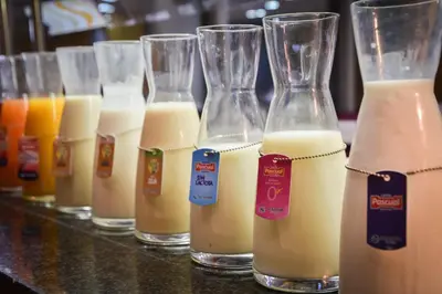 a row of glasses filled with different types of milk at Senator Parque Central in Valencia