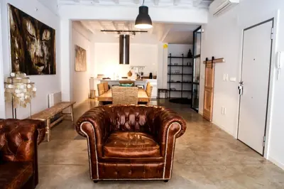 a living room with a leather couch and a dining room at Apartment Triador in Valencia