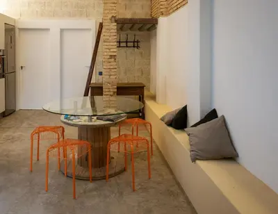 a dining room with a glass table and orange chairs at Beach loft in Valencia