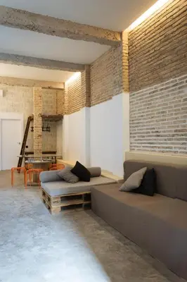 a living room with two beds and a brick wall at Beach loft in Valencia