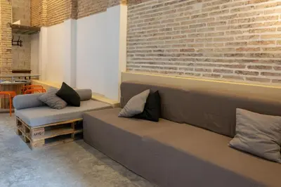 a living room with two couches and a brick wall at Beach loft in Valencia