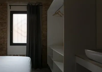 a bedroom with a bed and a sink and a window at Beach loft in Valencia