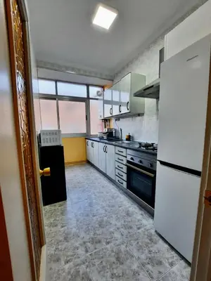 a kitchen with white appliances and a large window at Piso en la playa in Valencia