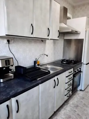 a kitchen with white cabinets and a sink at Piso en la playa in Valencia