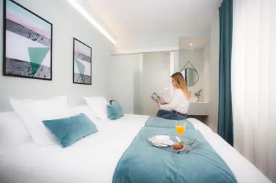 a woman sitting on a bed in a hotel room at Palacios Rooms in Valencia